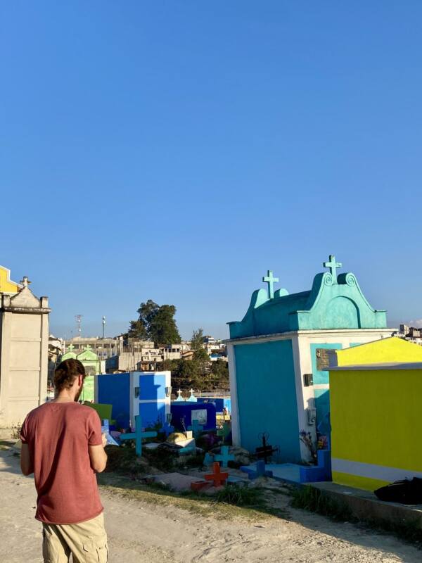 Alberto Jurada dibujando frente a las tumbas de colores del cementerio de Chichicastenango