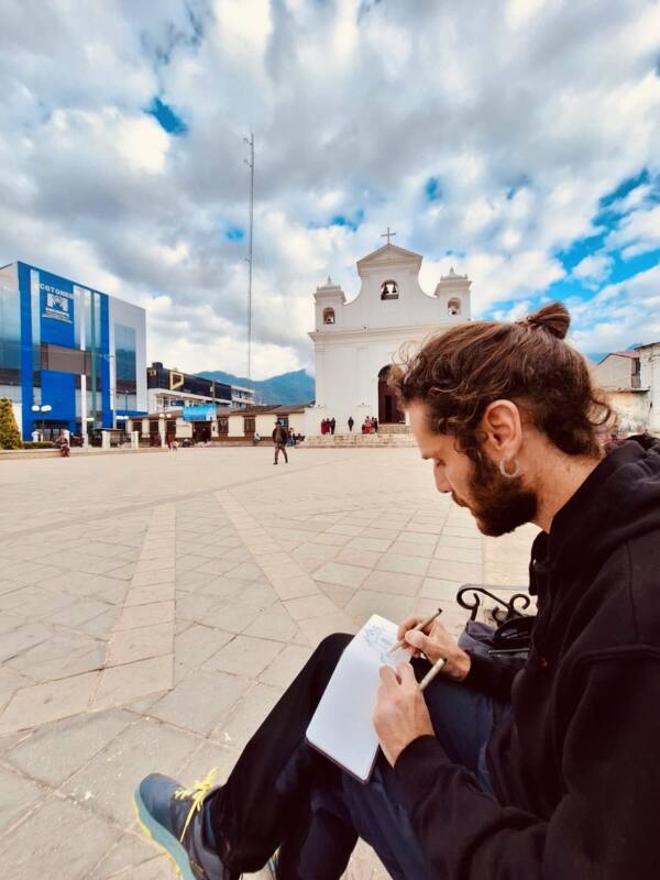 Alberto Jurada dibujando en su cuaderno en la plaza de Santa María Nebaj, Guatemala