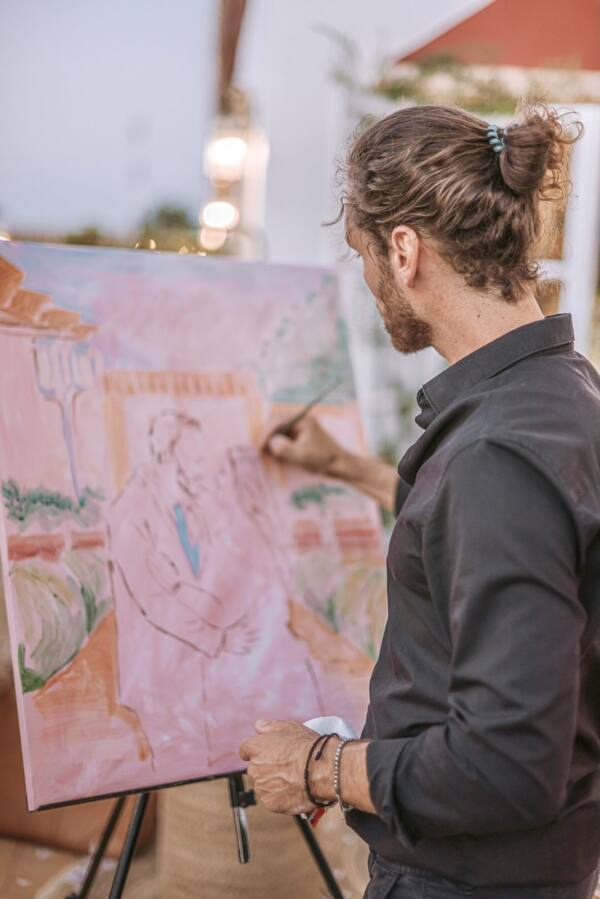 Alberto Jurada pintando en directo el boceto de los novios sobre fondo rosa