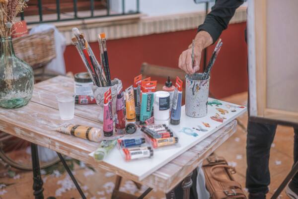 Mesa con pinceles y pinturas preparada para el live painting de una boda