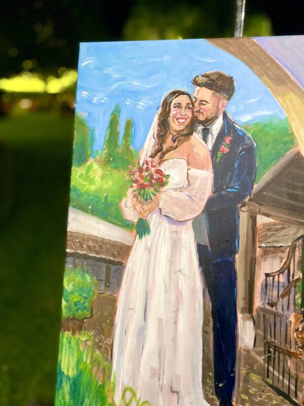 Cuadro de los novios bajo un arco con flores, pintado en directo en su boda
