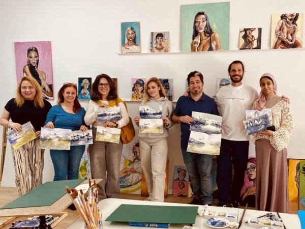 Grupo de alumnos adultos enseñando sus acuarelas al terminar un taller en el estudio Dibujo Libre