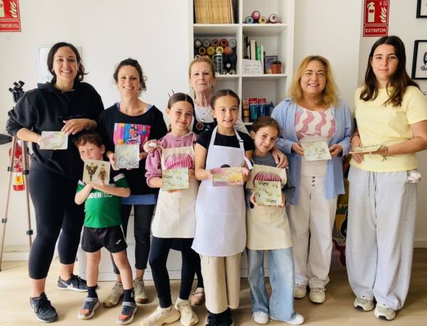 Madres e hijos enseñando las piezas que han pintado en el taller del Día de la Madre