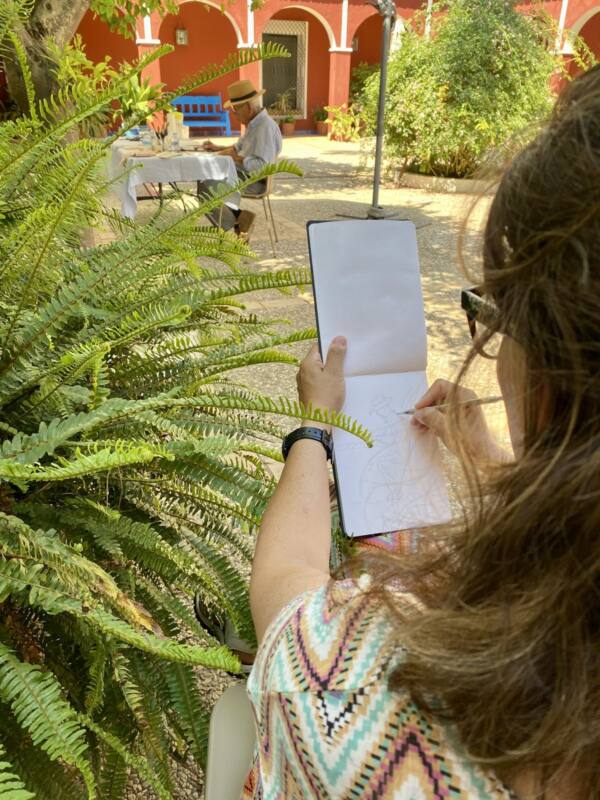 Alumna dibujando en su cuaderno al aire libre en el taller de urban sketching
